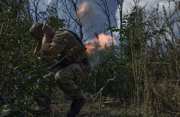 A Ukrainian soldier fires a mortar towards the Russian positions near Bakhmut, Donetsk region, Ukraine, Saturday, Sept. 2, 2023. (AP Photo/Libkos)