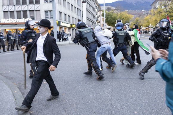 Des policiers antiemeute embarquent une personne lors d&#039;un rassemblement non autorise en solidarite avec le peuple palestinien ce samedi 1 novembre 2025 a Sion, en Suisse. (KEYSTONE/Cyril Zingaro ...