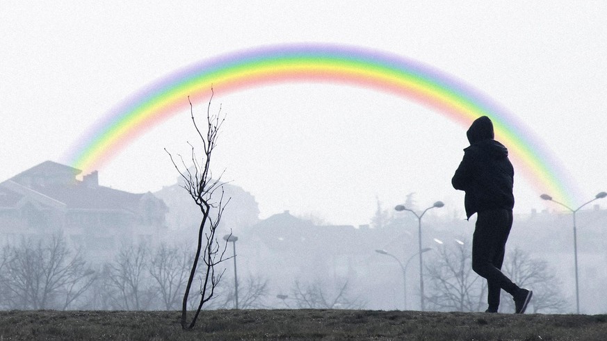 Silhouette of a teenage boy walking alone on a foggy misty winters day