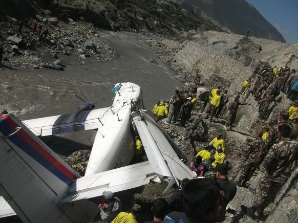 epa03703002 Rescue works are underway at the wreck of a Twin Otter plane of the Nepal Airlines on the banks of the Kali Gandagi river in the Mustang village, some 200 kilometers (125 miles) northwest  ...