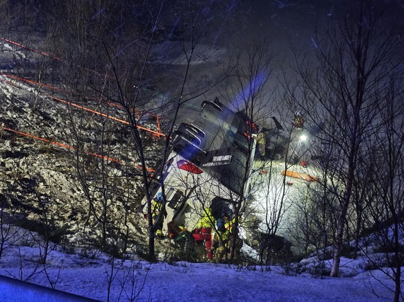 epa11794118 Members of the emergency services work after a bus went off the road on the E10 and plunged into a lake in Hadsel, Nordland, Norway, 26 December 2024. At least three people have died and f ...