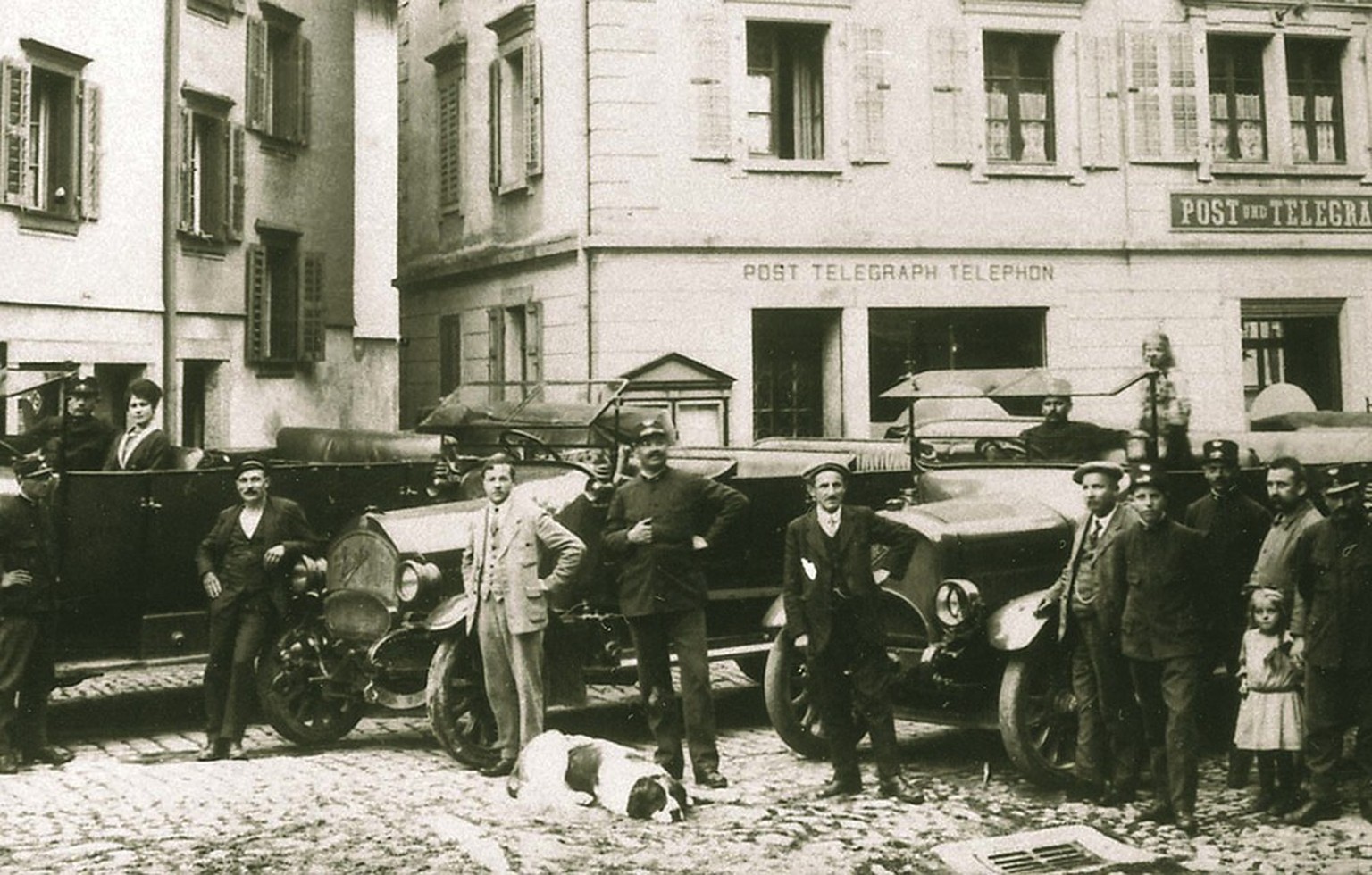 Automobiles sur la place du village à Andermatt, vers 1925.