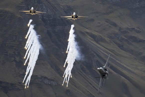 McDonnell Douglas F/A-18C Hornet fighter jets of the Swiss Air Force drop flares during the annual airshow of the Swiss Army in the Axalp area near Meiringen, Canton of Berne, Switzerland, Wednesday,  ...