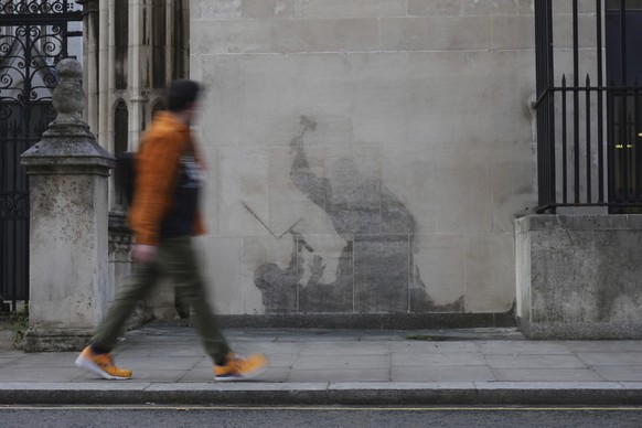 KEYPIX - The remains of Banksy's latest artwork outside at the Royal Courts of Justice, which shows a judge using his gavel to strike a protester, are visible after an attempt to remove it in Lon ...