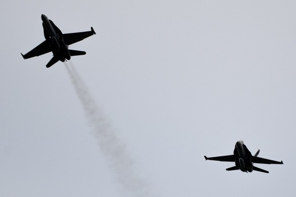 Un avion F/A-18, gauche, quitte la formation de l&#039; armee Suisse volant en formation &quot;Missing man formation&quot; en hommage au pilote du F/A-18 decede le 29 aout dans la region du Susten ce  ...