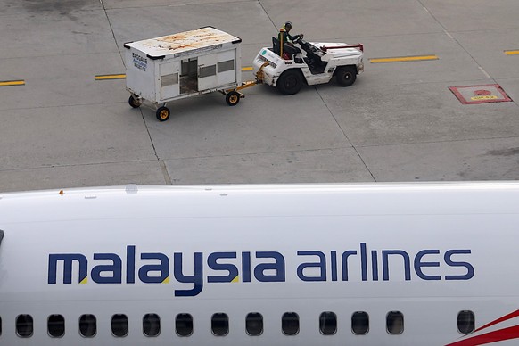 epa11948217 A worker drives past a Malaysia Airlines aircraft parked at the Kuala Lumpur International Airport, on the 11th anniversary of missing Malaysia airlines MH370 in Sepang, outside Kuala Lump ...