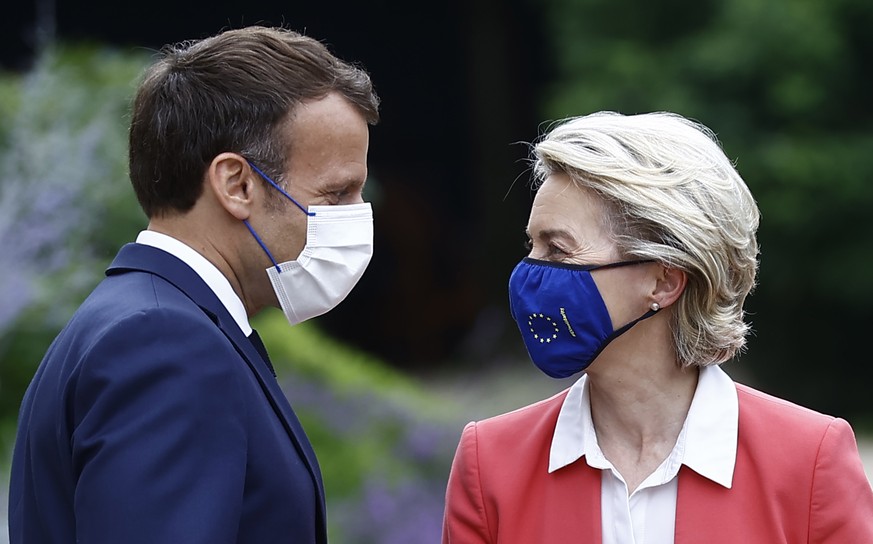 epa09296610 French President Emmanuel Macron (L) greets President of the European Commission Ursula von der Leyen (R) as she arrrives for a meeting at the Elysee Palace in Paris, France, 23 June 2021. ...