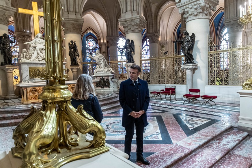 epa11747988 French President Emmanuel Macron (L) speaks with an art restorer during a visit of Notre-Dame de Paris cathedral in Paris, France, 29 November 2024. French President Macron is visiting the ...