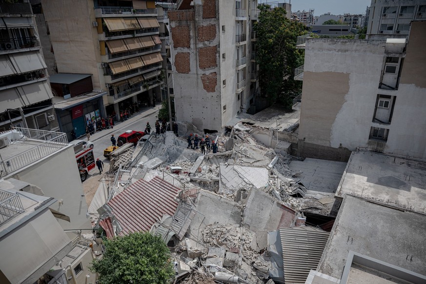 Emergency personnel search for victims amid the rubble at the site of a building collapse in the Petralona neighbourhood of Athens, on June 30, 2026. Construction work was underway on a neighboring pl ...