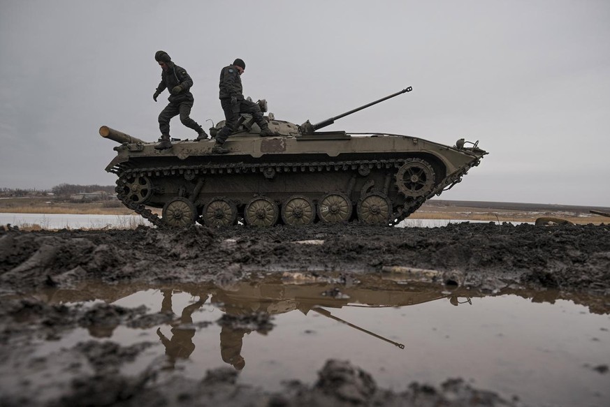 Ukrainian servicemen walk on an armored fighting vehicle during an exercise in a Joint Forces Operation controlled area in the Donetsk region, eastern Ukraine, Thursday, Feb. 10, 2022. A peace agreeme ...