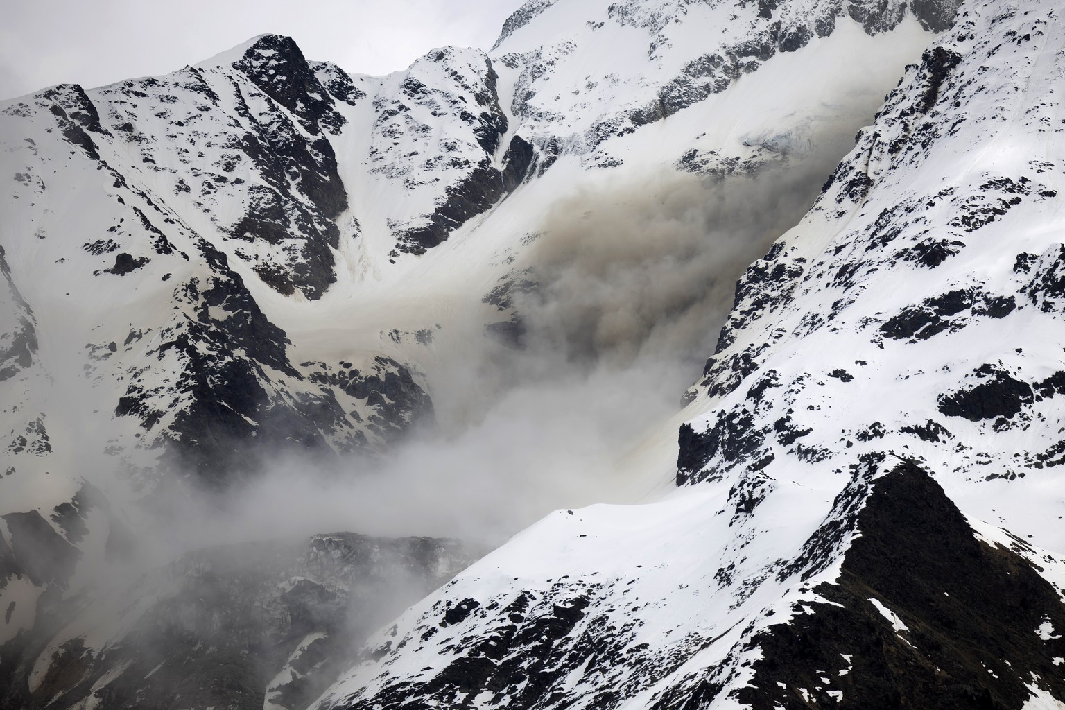 Quality Repeat: Staub von einem Felssturz steigt auf, an einer Flanke des Berges Bietschhorn im Loetschental, am Montag, 19. Mai 2025, aufgenommen von der Ortschaft Wiler. Das Dorf Blatten VS im Loets ...