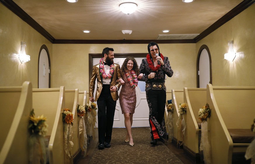 FILE - Elvis impersonator Brendan Paul, right, walks down the aisle during a wedding ceremony for Katie Salvatore, center, and Eric Wheeler at the Graceland Wedding Chapel in Las Vegas. Authentic Bran ...