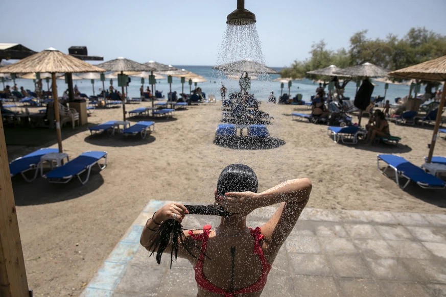 Une femme profite de la douche près d’Athènes.