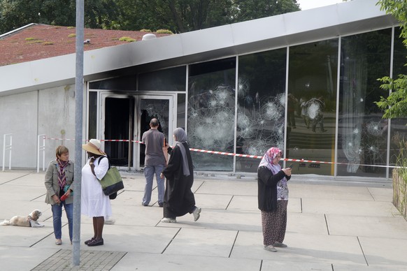 Residents walk past the damaged town hall of Mons-en-Bar?ul, northern France, Thursday, June 29, 2023. Protesters angry after police shot a 17-year-old boy dead set cars and buildings ablaze in Paris  ...