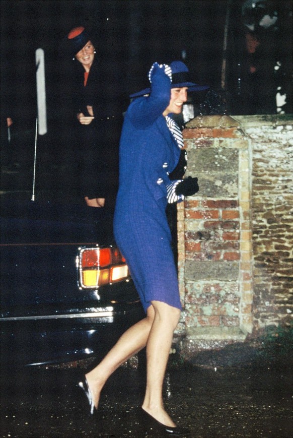 SANDRINGHAM, UNITED KINGDOM - DECEMBER 25: Diana, Princess of Wales, clutches her hat on the way to Sandringham Church for Christmas Day Service on December 25, 1990 in Sandringham, England. (Photo by ...