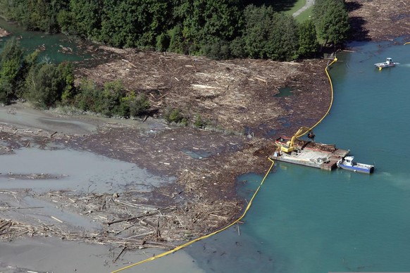 Noch immer sind Arbeiter dabei, Treibholz das infolge der Unwetter im Kanderdelta auf dem Thunersee gestaut wird, auf Schiffe zu laden und zu entsorgen, am Dienstag, 30. August 2005. (KEYSTONE/Yoshiko ...