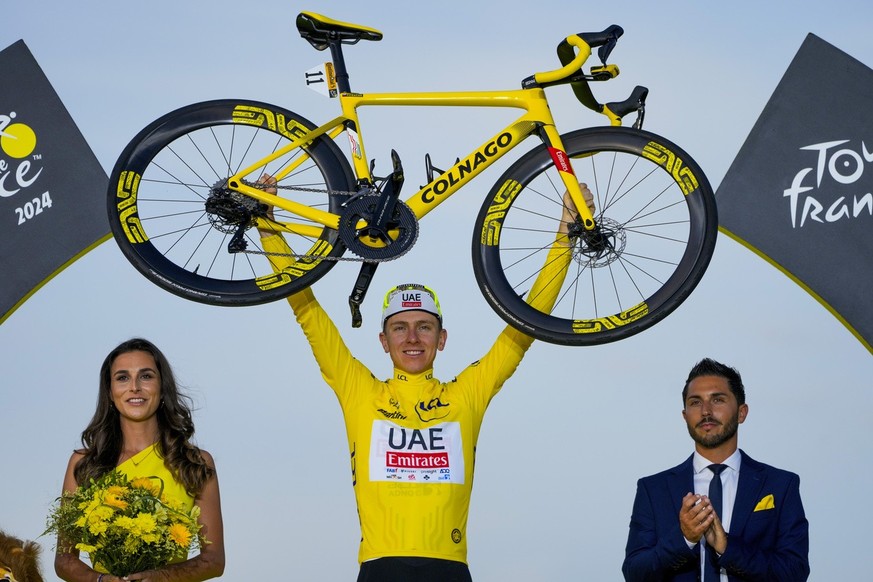 Tour de France winner Slovenia&#039;s Tadej Pogacar, wearing the overall leader&#039;s yellow jersey, celebrates on the podium after the twenty-first stage of the Tour de France cycling race, an indiv ...
