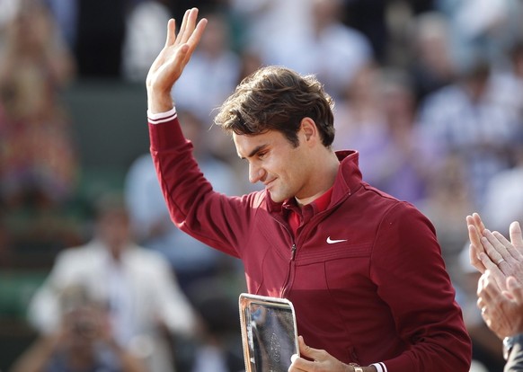 epa02767821 Roger Federer of Switzerland waves to the crowd after having received his finalist trophy. Federer lost to Rafael Nadal of Spain in the men's final match for the French Open tennis to ...