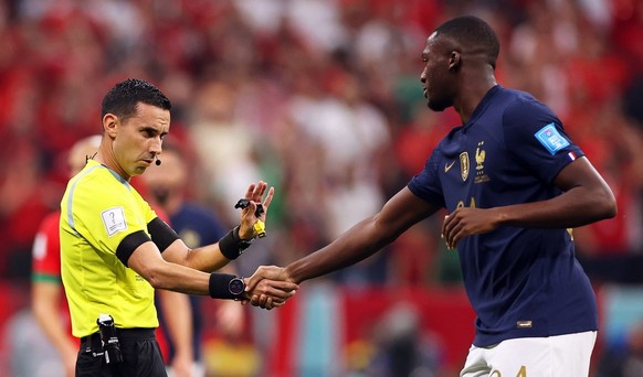epa10365922 Mexican referee Cesar Arturo Ramos (L) shakes hands with Ibrahima Konate (R) during the FIFA World Cup 2022 semi final between France and Morocco at Al Bayt Stadium in Al Khor, Qatar, 14 D ...