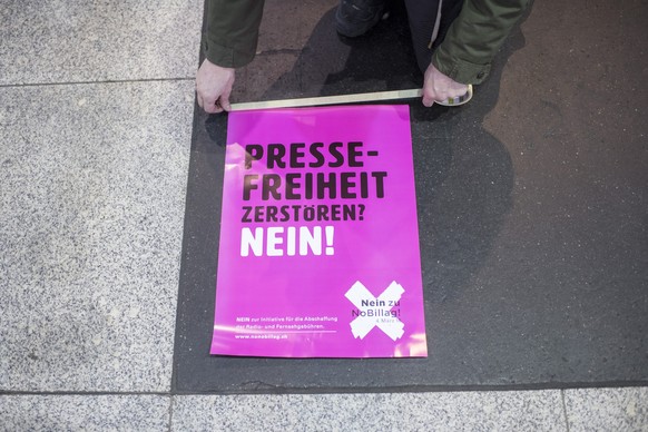Ein Mann klebt Plakate mit der Aufschrift &amp;quot;Pressefreiheit zerstoeren? Nein!&amp;quot; im Hauptbahnhof in Zuerich unter der &amp;quot;No Billag&amp;quot;-Aktion &amp;quot;Musik gegen den Sende ...