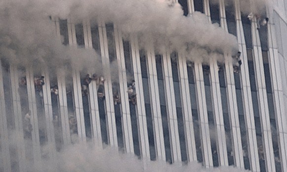 Des personnes sont suspendues aux fenêtres brisées de la tour nord du World Trade Center à New York, le matin du 11 septembre 2001.