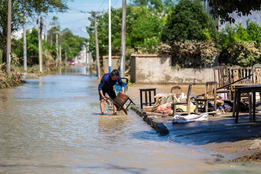 epaselect epa11513135 A villager cleans a chair at Huazhong Village of Hekou Town, Xiangtan County, central China&#039;s Hunan Province, July 31, 2024. Heavy rainfall has affected 1.15 million people  ...