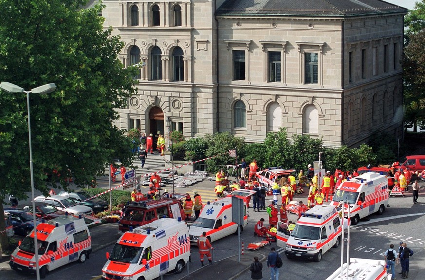 Ambulance cars stand ready in front of the local parliament building of central Swiss town of Zug, where a gunman stormed the local assembly and opened fire on Thursday, September 27. 2001. Probably 1 ...