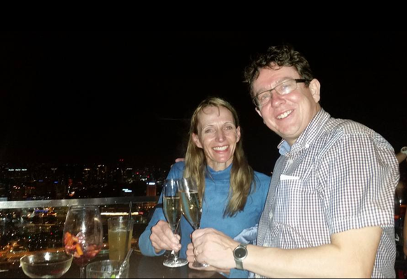 Albert Rösti prend une coupe de champagne à Singapour, avec sa femme.