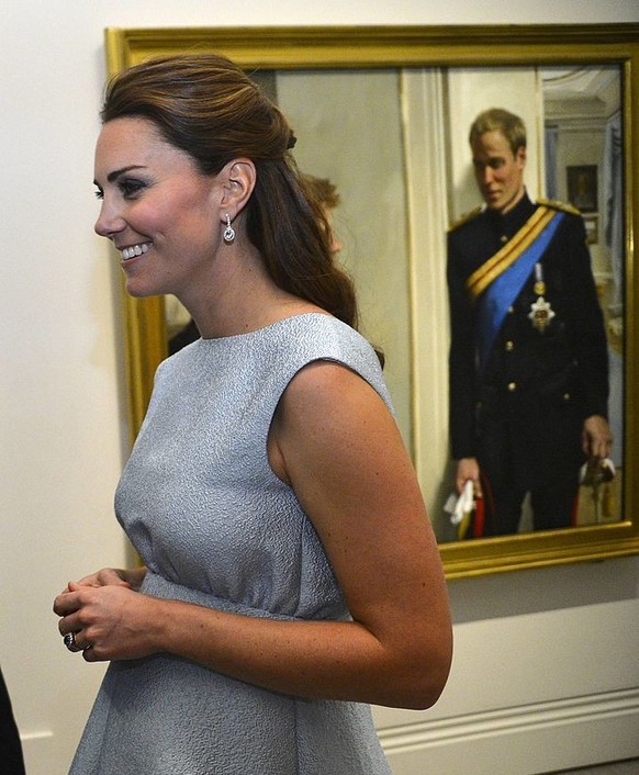 LONDON, ENGLAND - APRIL 24: Catherine, Duchess of Cambridge passes a painting of her husband Prince William during an evening reception to celebrate the work of The Art Room charity at The National Po ...