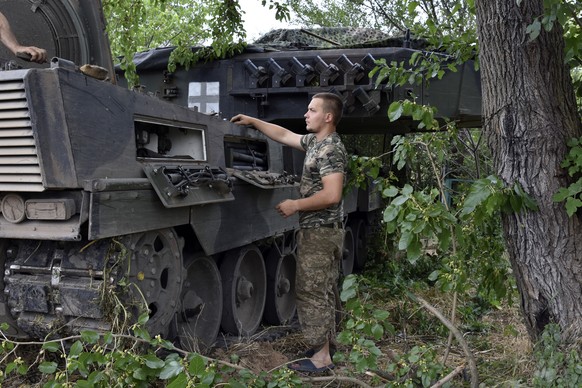 Ukrainian soldiers repair a Leopard 2 tank in Zaporizhzhya region, Ukraine, Wednesday, June 21, 2023. (AP Photo/Andriy Andriyenko)