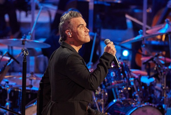 15.11.2022, Hamburg: Robbie Williams, britischer SÃ¤nger und Songwriter, sowie Musiker des Orchesters der Neuen Philharmonie Frankfurt stehen auf der BÃ¼hne im GroÃen Saal in der Elbphilharmonie. Wil ...