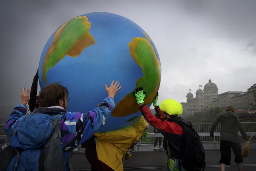 Klimaaktivisten protestieren mit eine aufblasbare Weltkugel waehrend ihrer Aktionswoche Rise up for Change, am Freitag, 25. September 2020, auf dem Kirchenfeldbruecke in Bern. (KEYSTONE/Anthony Anex)