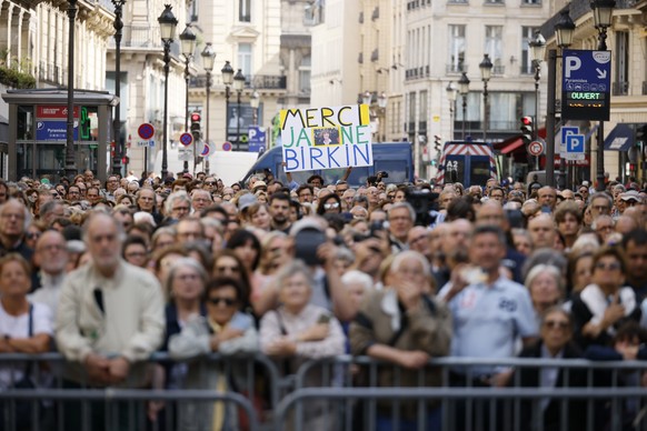 Une foule attend devant l'église Saint-Roch lors des funérailles de Jane Birkin à Paris.