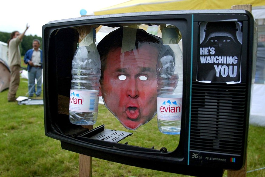 A mock TV set shows a cartoon of US president Georges W. Bush framed by two Evian water bottles, at a camping place of anti-globalisation groups in Lausanne, Switzerland, Sunday, May 25, 2003. Members ...