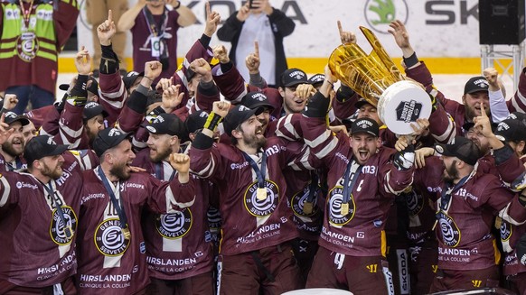 Geneva&#039;s players celebrate with the trophy of Swiss Champion after winning by 4:1 the seventh and final leg of the ice hockey National League Swiss Championship final playoff game between Geneve- ...