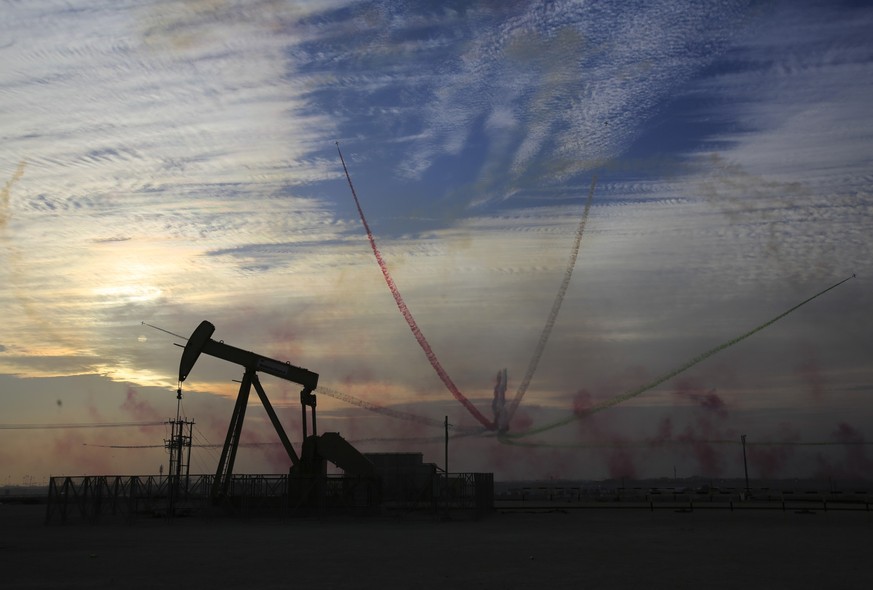 An oil pump works as Al Fursan, the aerobatics demonstration team of the United Arab Emirates Air Force, performs during the Bahrain International Airshow in Sakhir, Bahrain, Saturday, Jan. 23, 2016.  ...