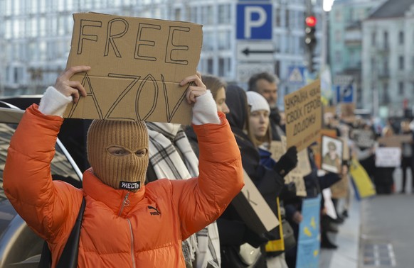 epa11050486 An Ukrainian woman holds a placard reading &#039;Free Azov&#039; during a rally in downtown Kyiv, Ukraine, 31 December 2023, calling for authorities to return their relatives from Russian  ...