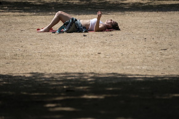A woman sunbathes in St James's Park, London, Tuesday July 19, 2022. Britain shattered its record for highest temperature ever registered Tuesday, with a provisional reading of 39.1 degrees Celsi ...