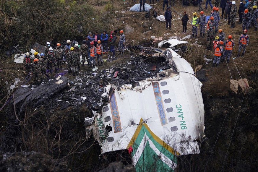 Rescuers scour the crash site in the wreckage of a passenger plane in Pokhara, Nepal, Monday, Jan.16, 2023. Nepal began a national day of mourning Monday as rescue workers resumed the search for six m ...