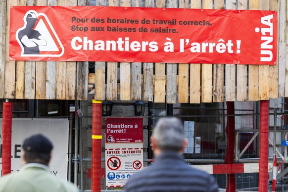 Une banderole denoncant leurs conditions de travail est posee sur un chantier en greve, lors de la premiere journee de greve des macons, ce lundi 3 novembre 2025 a Geneve. (KEYSTONE/Salvatore Di Nolfi ...