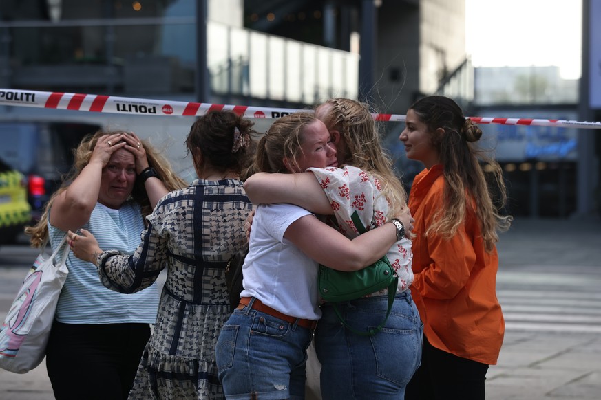 Peope react outside Field&#039;s shopping center in Copenhagen, Denmark, Sunday July 3, 2022. Danish police say several people have been shot at a Copenhagen shopping mall. Copenhagen police said that ...