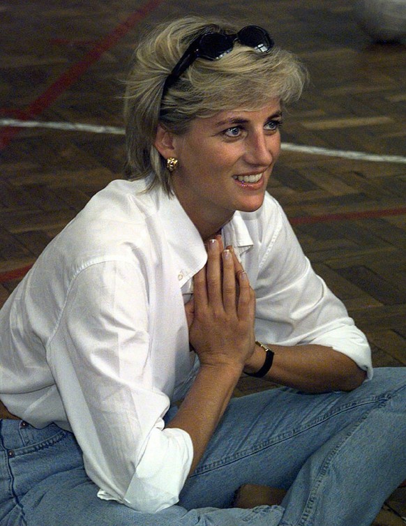 FILE - In this Saturday, Aug. 9, 1997 file photo, Diana, Princess of Wales, sits and talks to members of a Zenica volleyball team who have suffered injuries from mines, during her visit to Zenica, Bos ...