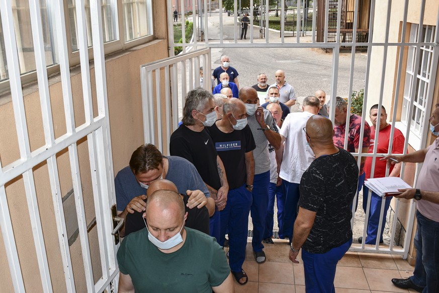In this image released by Bosnia's Prison Administration inmates wait to get a COVID-19 vaccine at a prison in Zenica, Bosnia, Wednesday, Aug. 18, 2021. While Bosnia remains a laggard of Europe i ...