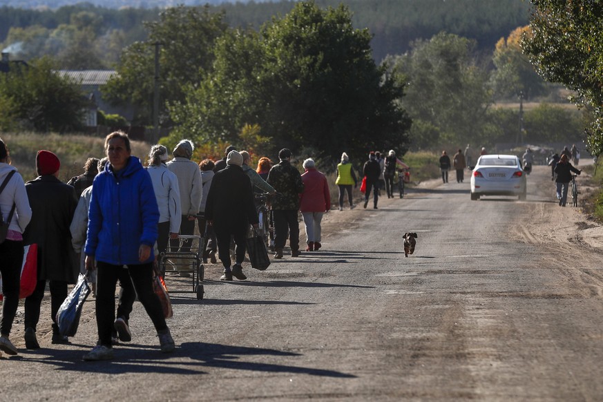 epa10227217 Residents of Kapytolyvka return to their homes after a truck carrying humanitarian aid truck was unable to arrive, east of Izyum, Kharkiv Oblast, Ukraine, 06 October 2022. .Russian troops  ...
