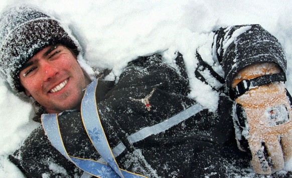 Der Schweizer Snowboarder Ueli Kestenholz waelzt sich am Montag, 9. Februar 1998, im Schnee von Shiga Kogen, geschmueckt mit der Bronzemedaille, die er am Vortag am olympischen Snowboard- Riesenslalom ...