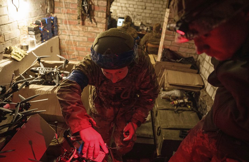 A Ukrainian soldier, aka Manul, of the ACHILLES battalion of the 92nd brigade, carries a suicide FPV drone to take-off position before flight over Russian positions in Kharkiv region, Ukraine, Sunday, ...