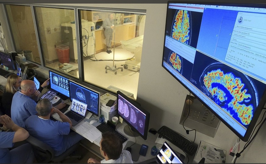 In this photo provided by the WVU Rockefeller Neuroscience Institute, the WVU RNI team in the MRI suite?s control area, plans ultrasound blood-brain barrier treatment in Morgantown, W.Va., on April 11 ...