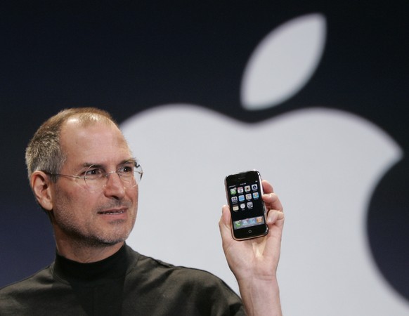 FILE - Apple CEO Steve Jobs holds up an Apple iPhone at the MacWorld Conference in San Francisco on Jan. 9, 2007. The iPhone introduced the convenience of touchscreens at the time that a physical keyb ...