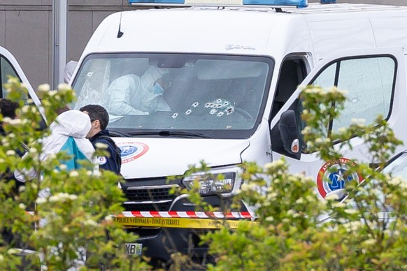epa11340384 French forensic police inspect a vehicle at the toll station of Incarville, near Rouen, in the North of France, where gunmen ambushed a prison van on 14 May 2024, killing two prison guards ...