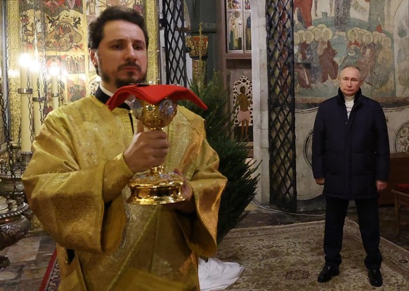 epa10393552 Russian President Vladimir Putin (R) attends a Christmas service at the Annunciation Cathedral in the Kremlin in Moscow, Russia, 07 January 2023. The Russian Orthodox church celebrates Chr ...